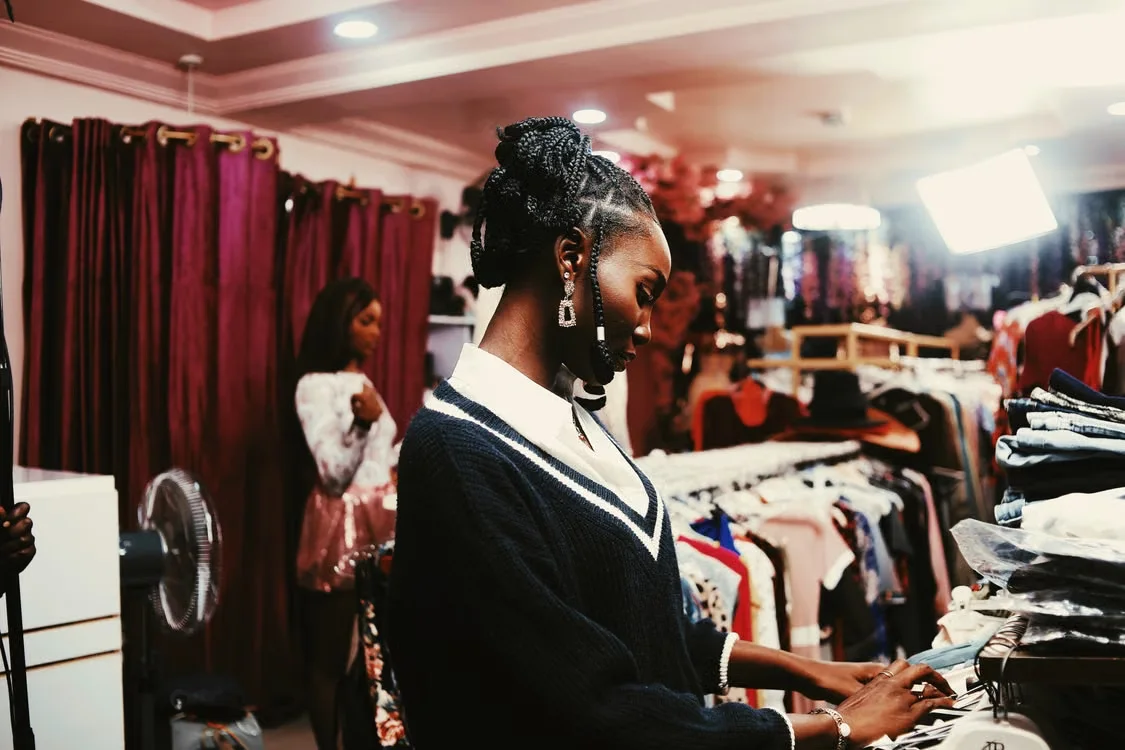 Customer looking through clothes on a rail in a boutique.